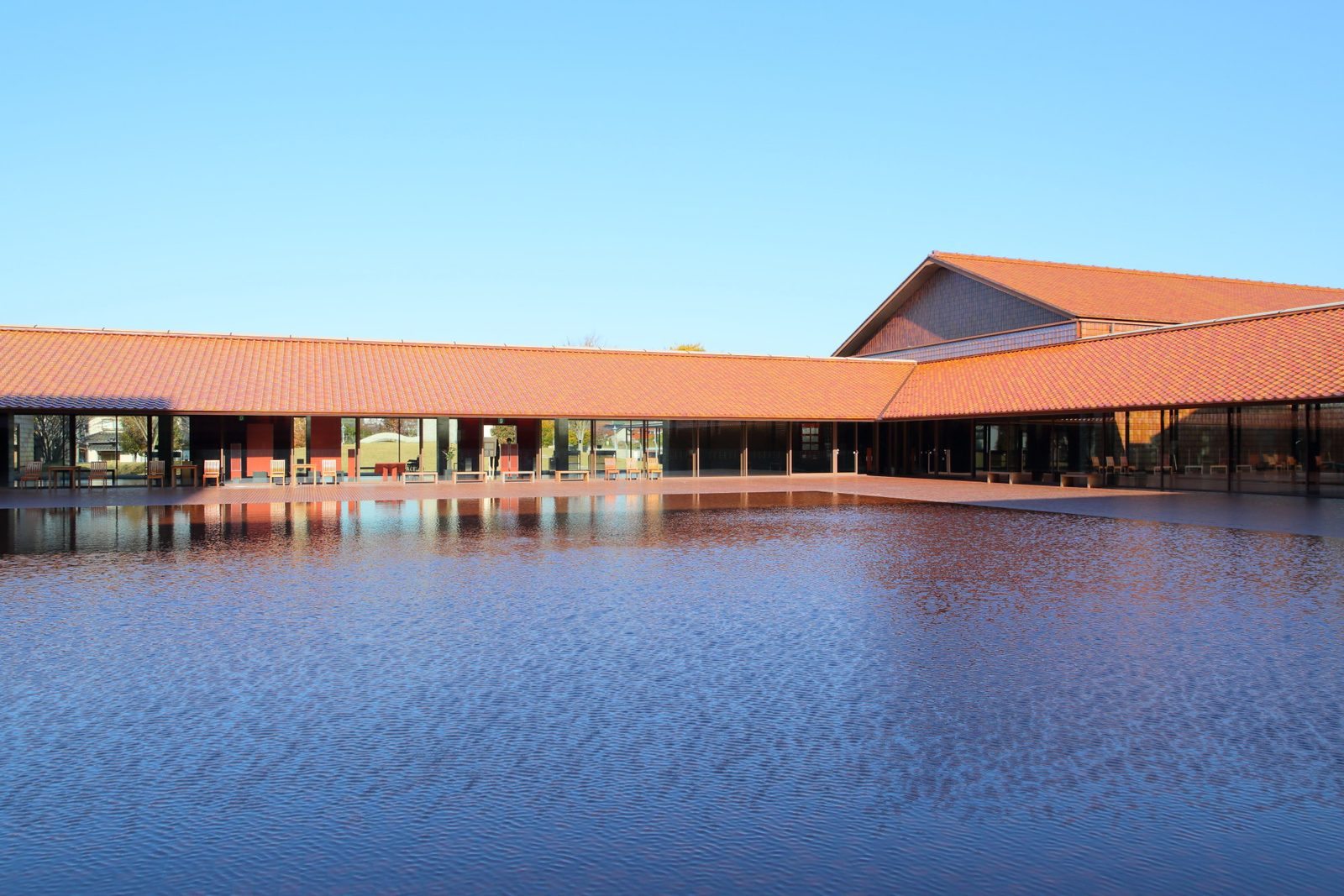 The water basin and red clay-tiled roofs of Grand Toit, the Shimane Arts Center in Masuda