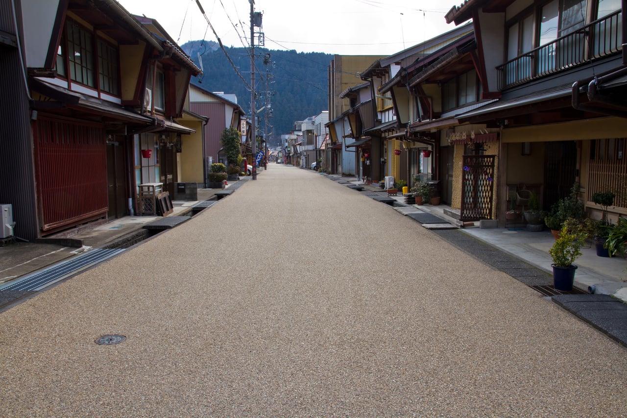 An empty traditional street lined with wooden machiya houses in the old town of Gujo Hachiman, Gifu.