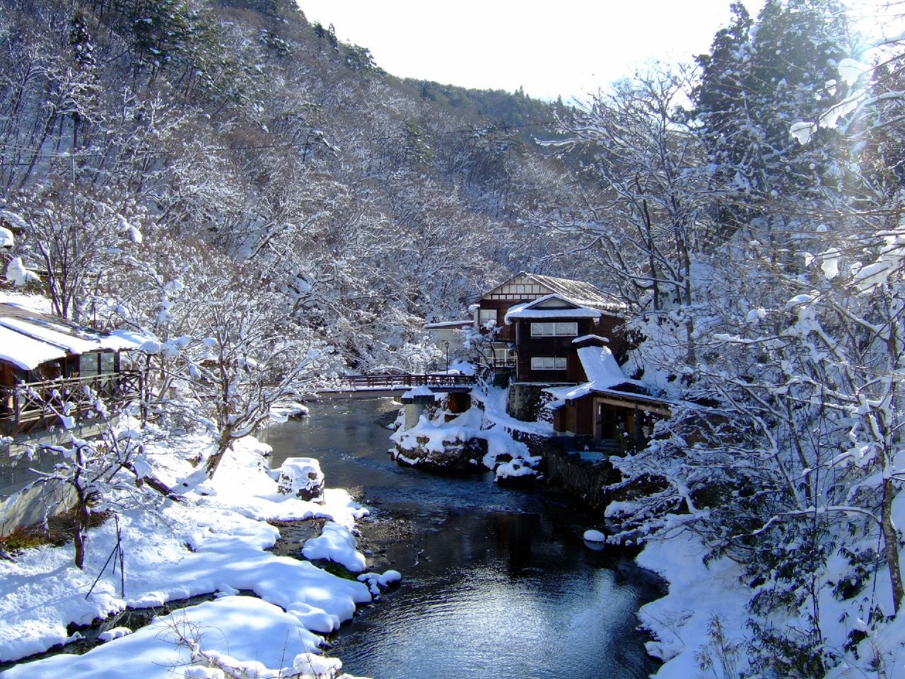 A snow-covered lane between traditional wooden hot-spring buildings at Osawa Onsen, one of the hot springs along the same river valley as Shidotaira Onsen in Hanamaki, Iwate.