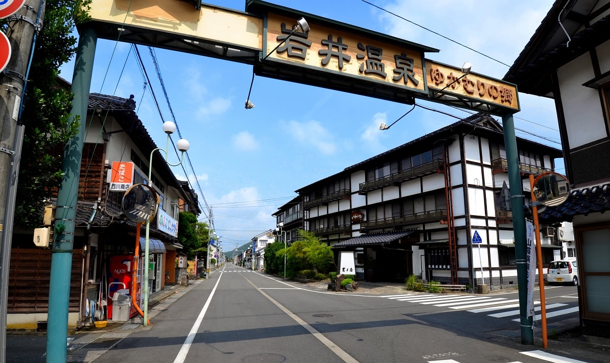 A quiet street lined with traditional two-story wooden inns in Iwai Onsen, a small hot-spring town in Iwami, Tottori.