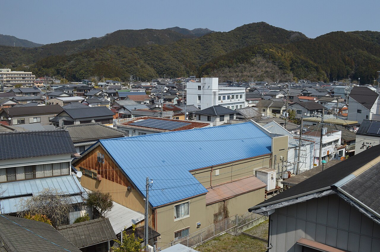 Rooftops of Kure town with green hills behind
