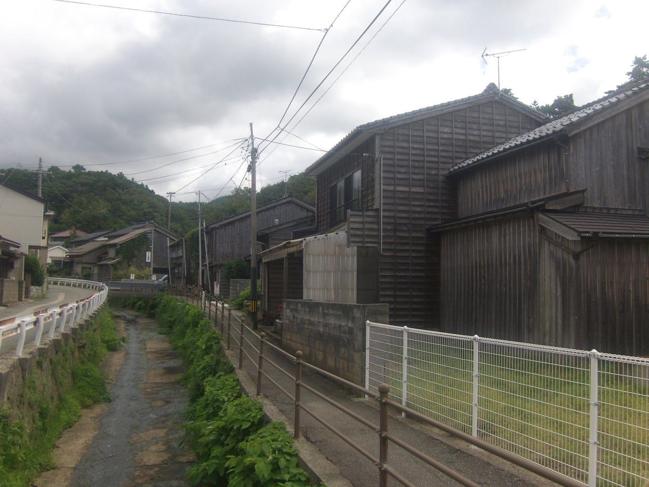 A quiet street of weathered wooden buildings in the old mining town of Aikawa on Sado Island.