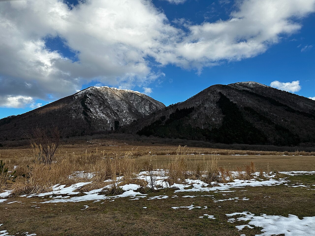 Mount Sanbe and its winter grassland with a small hut and patches of snow