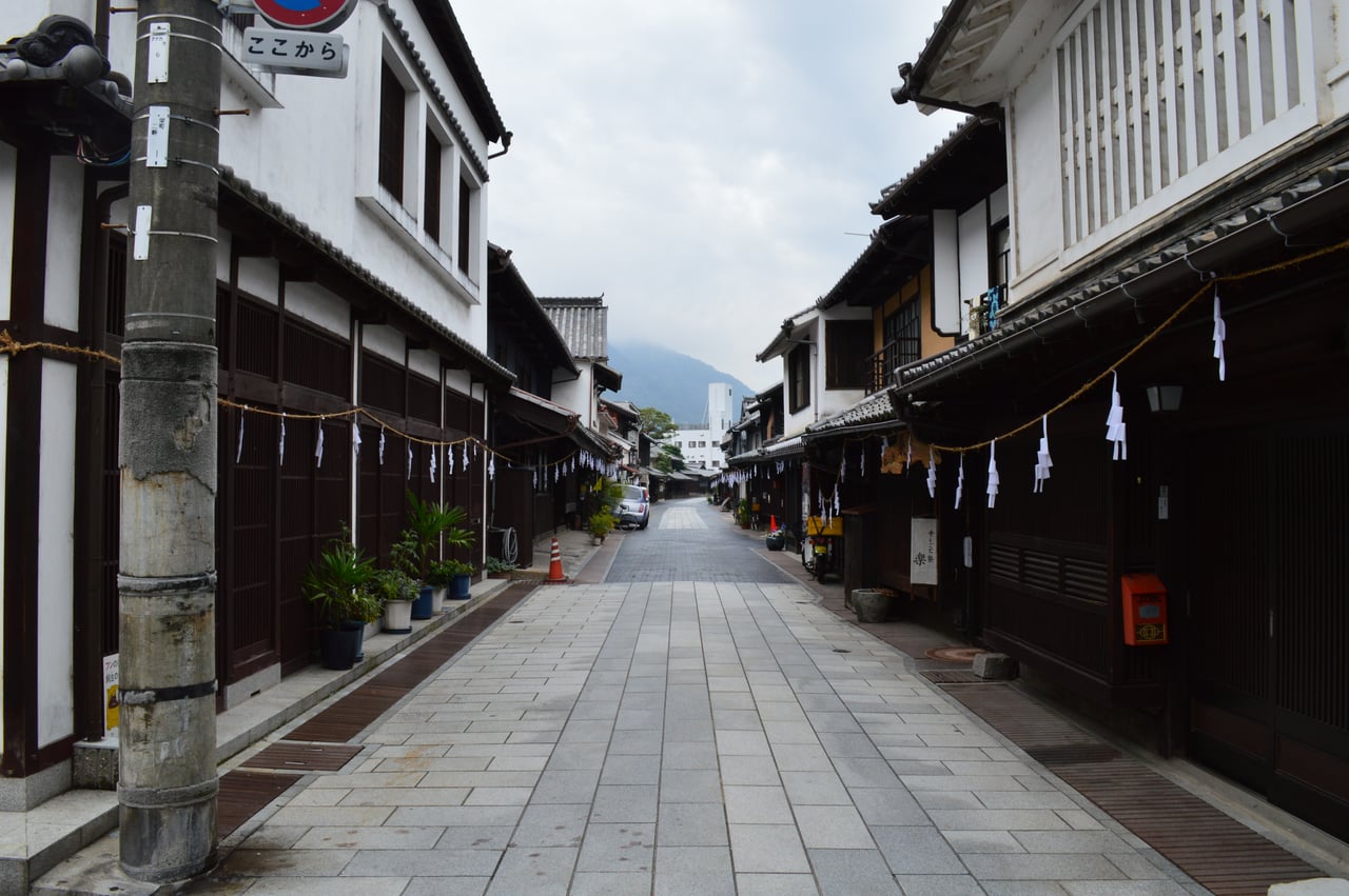 A street of white-walled traditional merchant houses with wooden lattice windows in the preserved historic district of Takehara, Hiroshima.