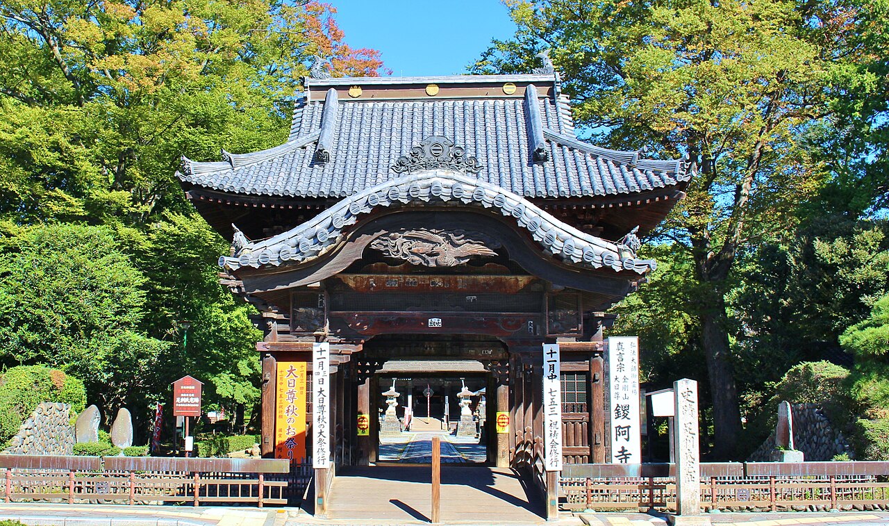 The two-storey gate of Banna-ji with carved panels on its front and banners beside it