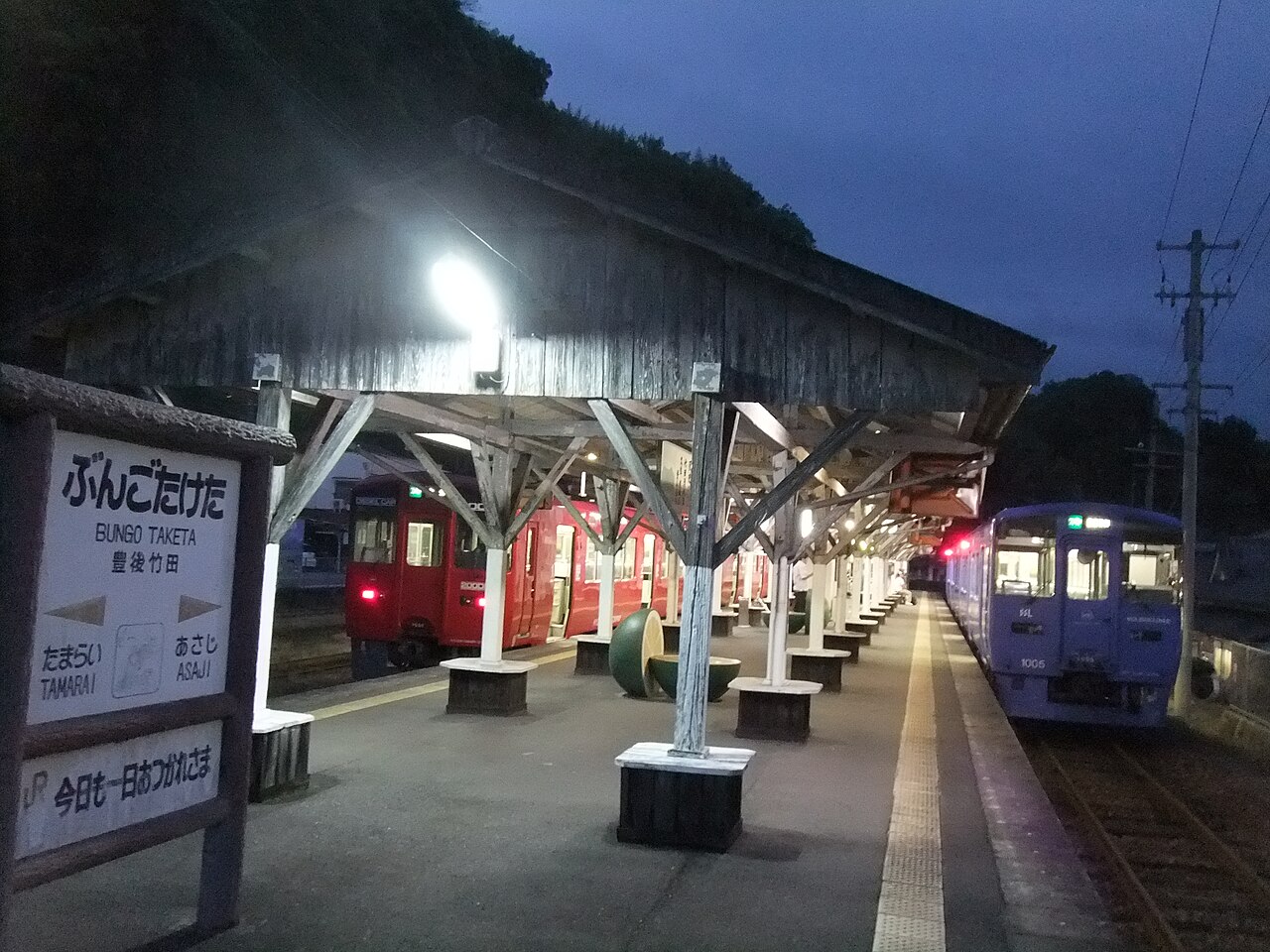 Evening platform at Bungo-Taketa Station with a local train waiting