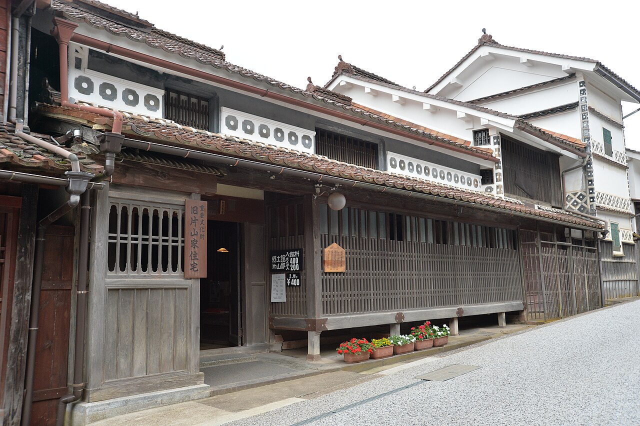 The street front of the former Katayama residence in Fukiya, with timber lattice, white plaster walls and decorative roundel panels