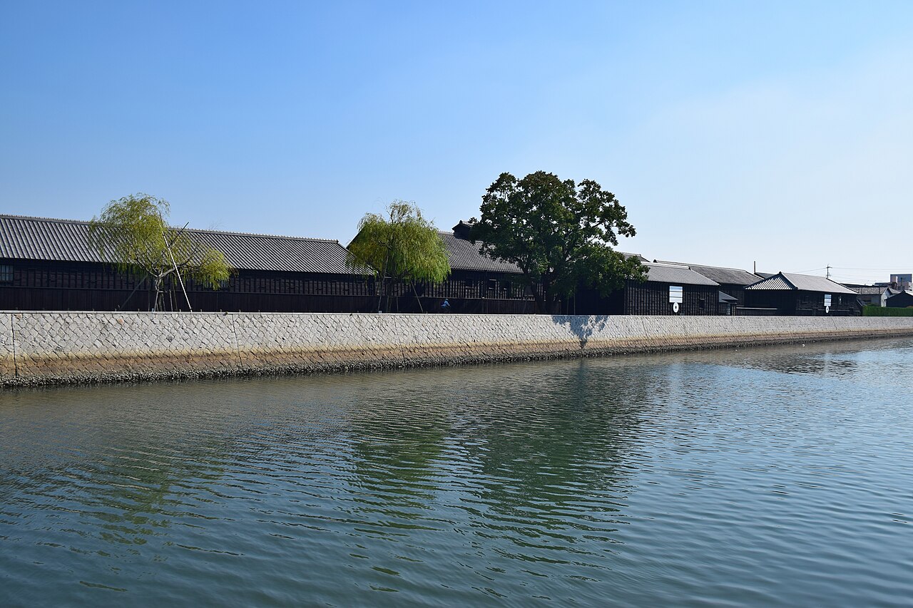 Black wooden brewery storehouses lining the Handa Canal under a clear sky