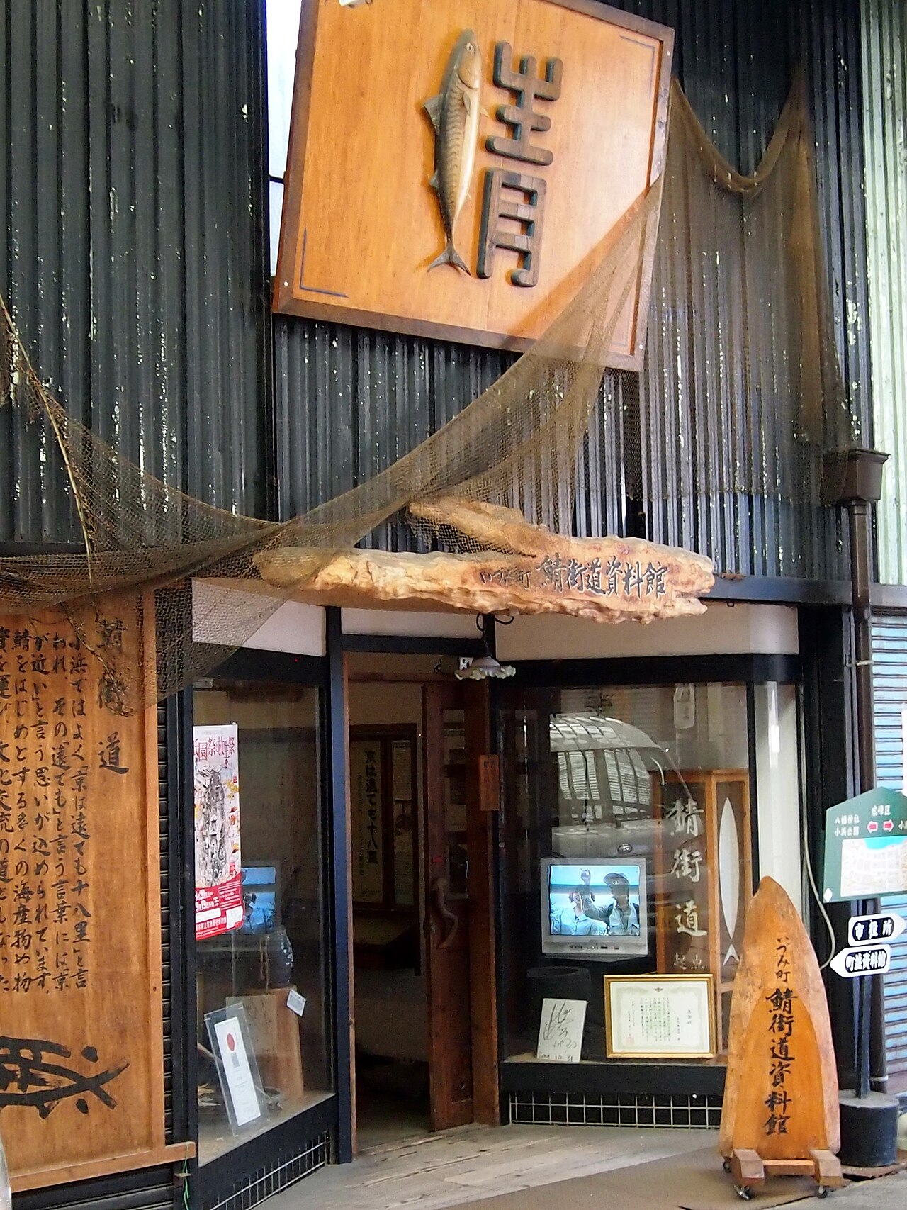 Entrance of the Saba Kaido Museum inside the Izumi-cho arcade in Obama, with a carved wooden mackerel sign and fishing nets