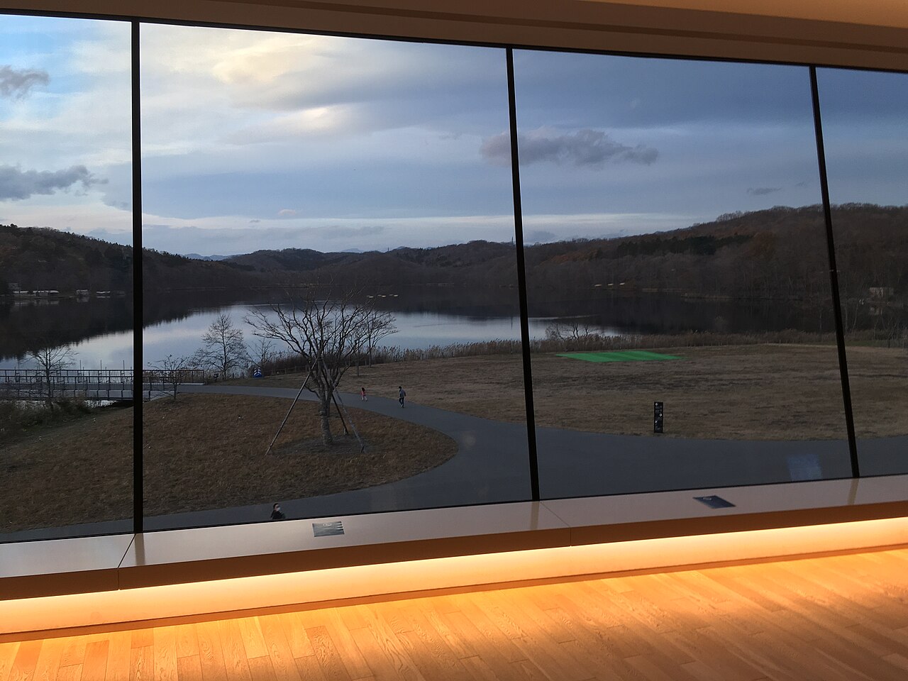 Lake Poroto and the wooded hills seen through the tall windows inside the National Ainu Museum
