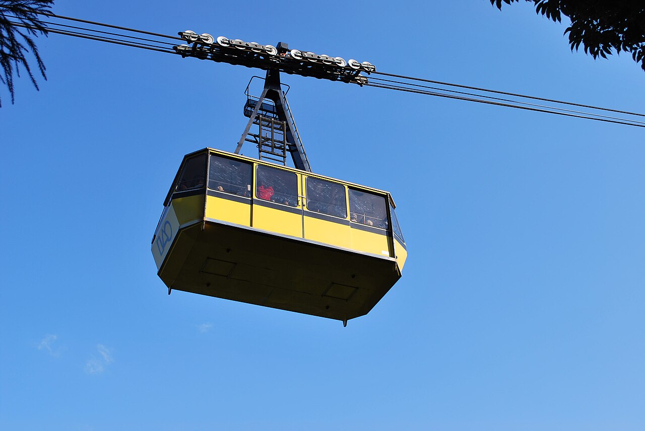 A yellow gondola of the Tairyuji Ropeway above the forested slope