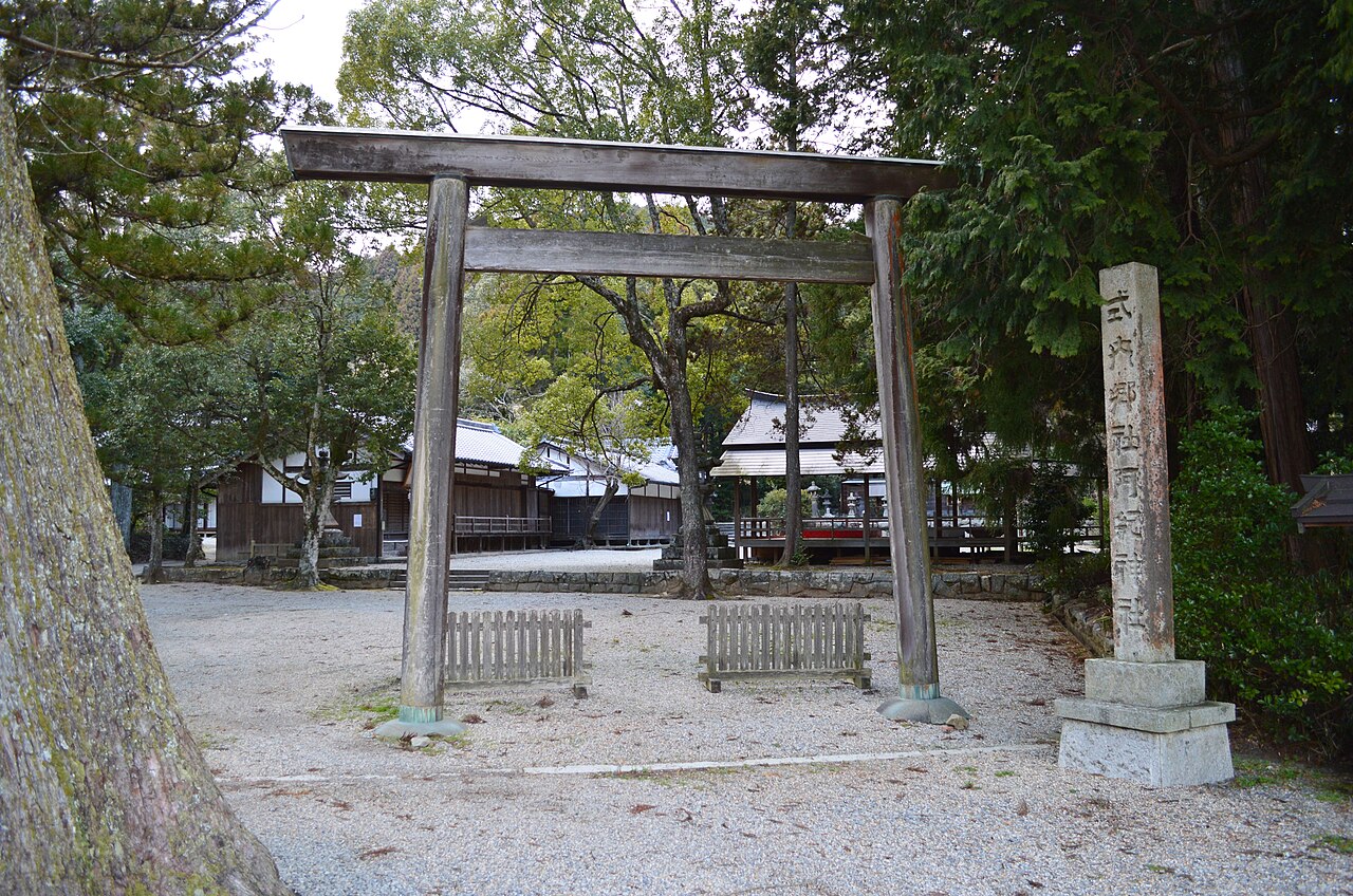 A wooden torii and stone marker in the gravel grounds of Aki Shrine