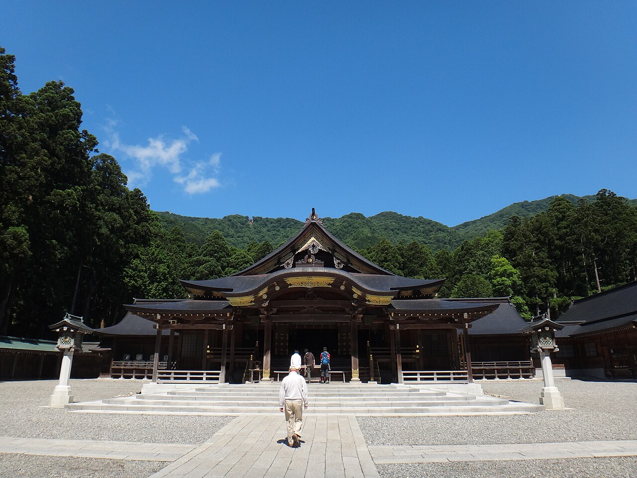 The worship hall of Yahiko Shrine with the forested slope of Mount Yahiko rising behind it